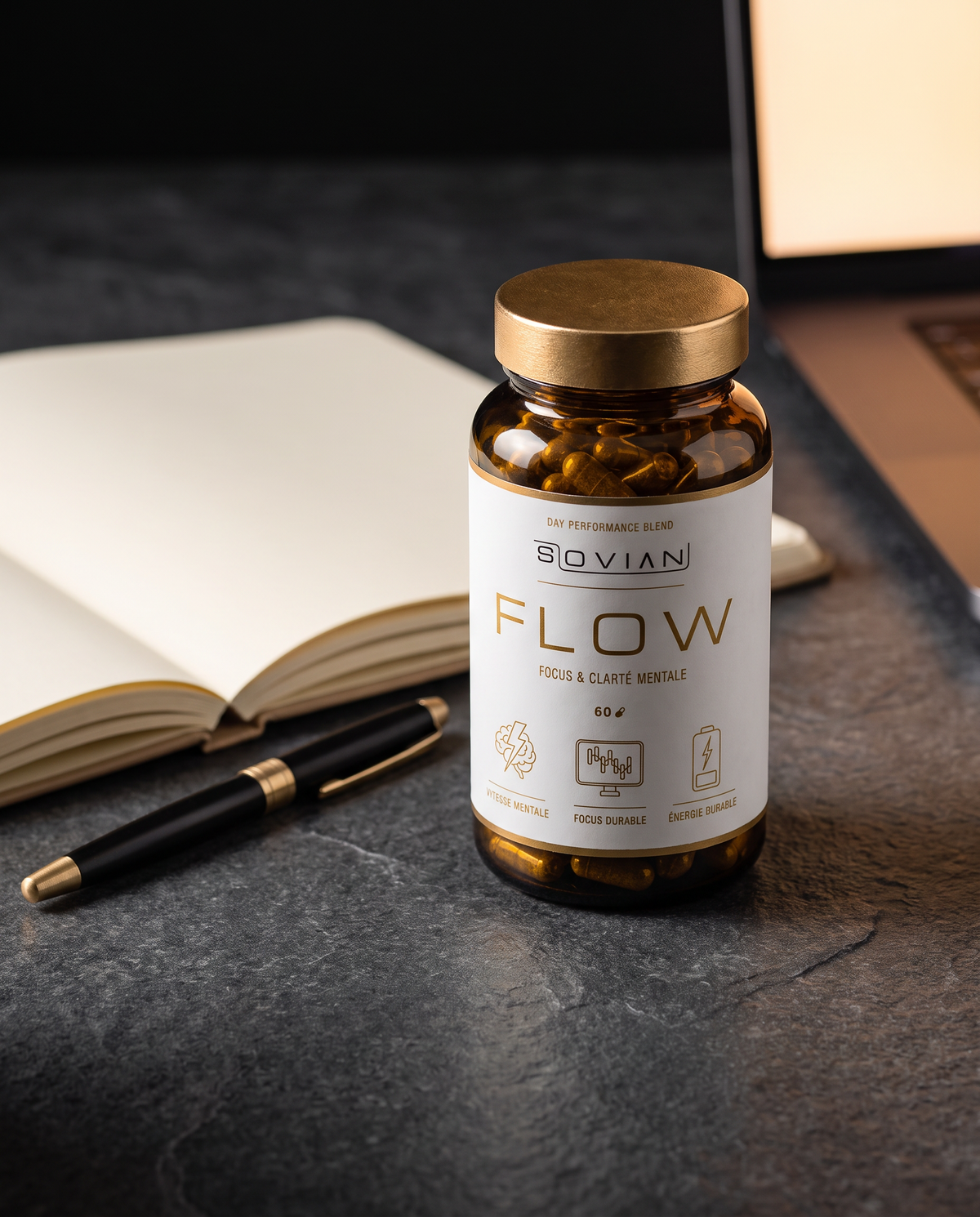 Flacon FLOW sur un bureau avec carnet et ordinateur