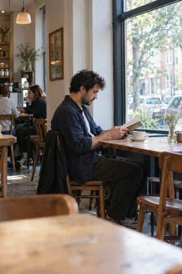 Un lecteur concentré dans un café, photographié sur le vif