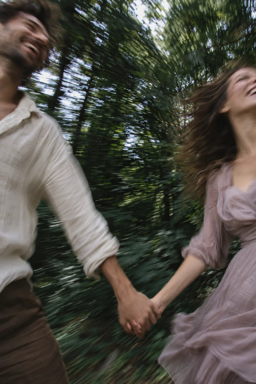Deux adultes pris dans un mouvement spontané, main dans la main sous les arbres